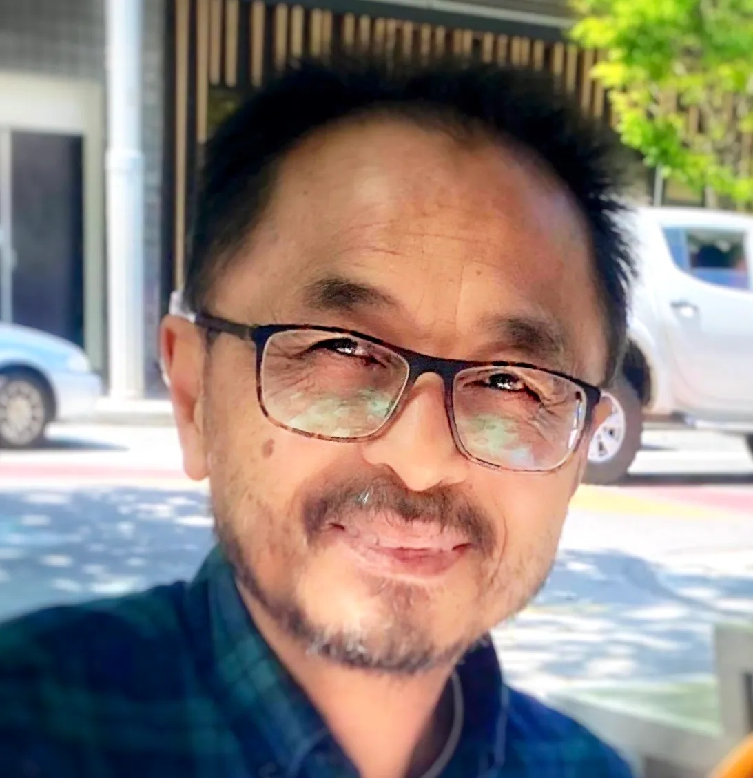 Ot Ratsaphong, archetypal coach, smiling outdoors